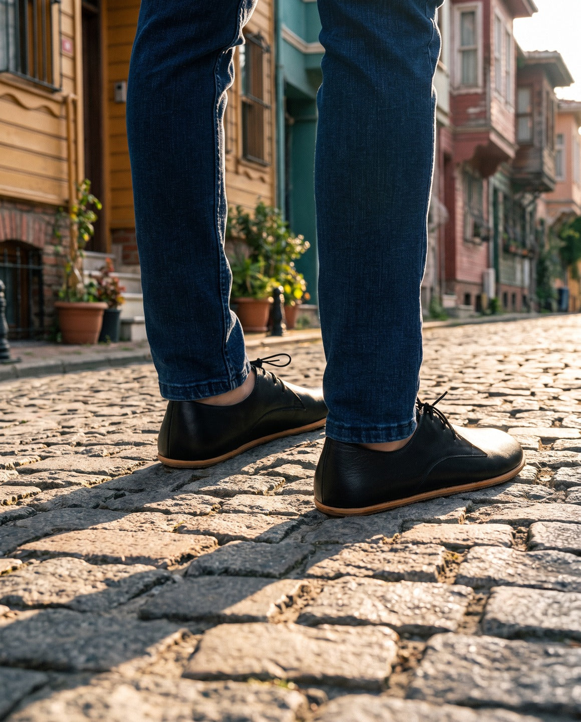 Black barefoot Oxford shoes worn on a cobblestone street in Balat, Istanbul (AI-assisted background, real Bespoky product) [S1-balat-oxford_v1.png]