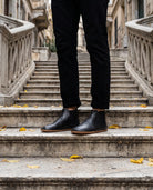 Men's black barefoot Chelsea boots on the old stone stairs of Galata, Istanbul (AI-assisted background, real Bespoky product) [S2-galata-chelsea_v1.png]