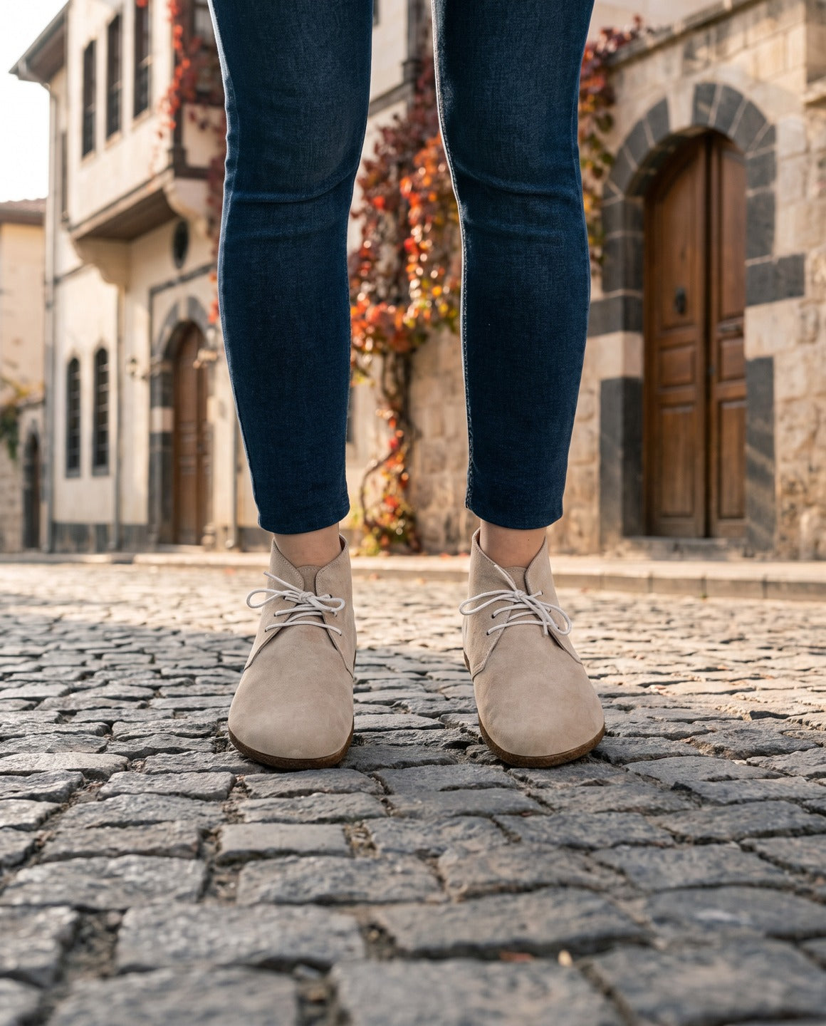 Women's beige nubuck barefoot ankle boots on a limestone street in Gaziantep (AI-assisted background, real Bespoky product) [S4-antep-sokak-bejbot_v1.png]